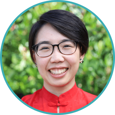 Headshot of Dr. Justine Fan, a trans Asian American person with short hair and glasses in a red blouse.