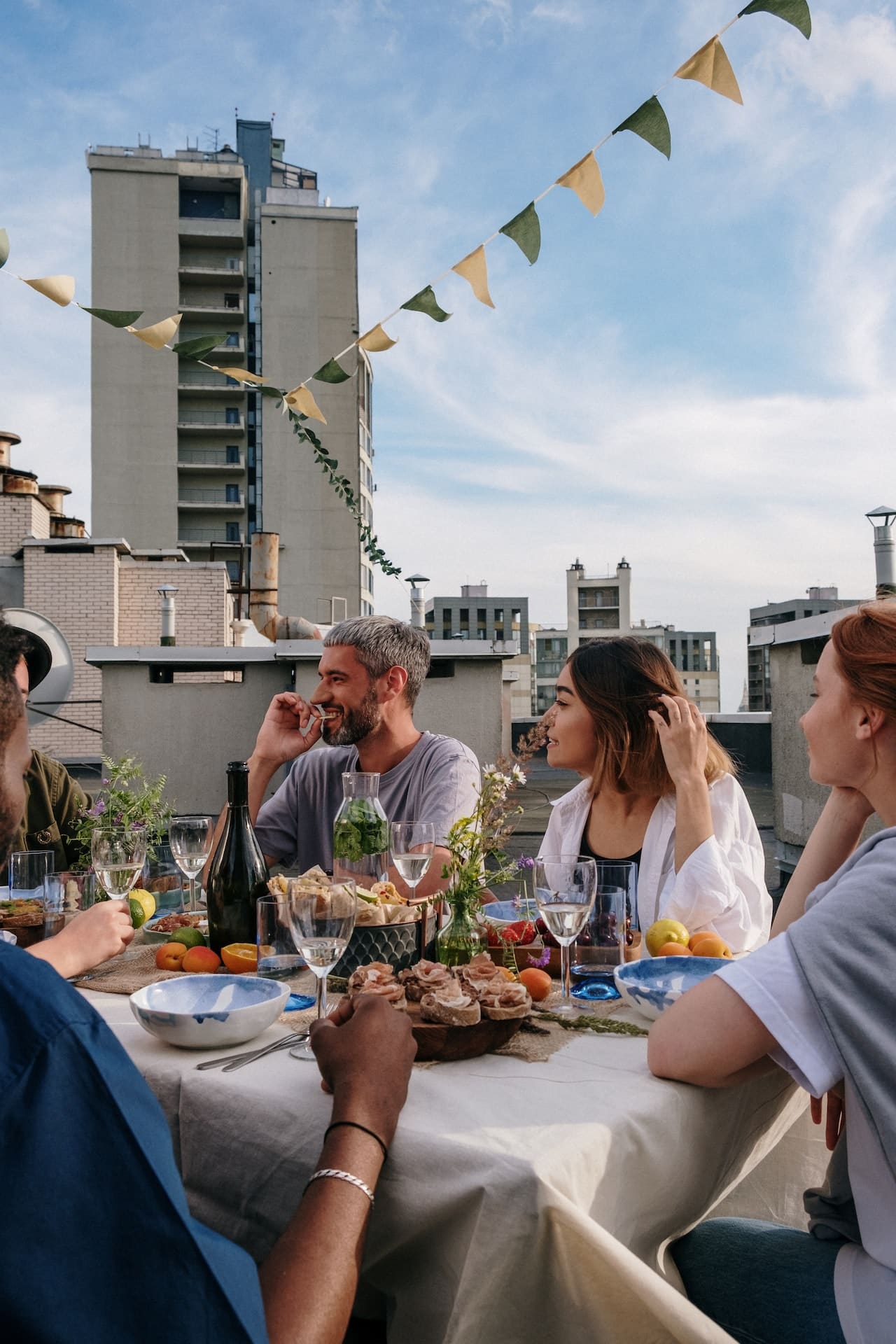 Group of people enjoying a casual meal together on a rooftop.