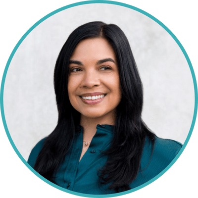 Headshot of Dr. Maya Borgueta, a Filipina psychologist with long dark hair in a turquoise dress. She is smiling and looking slightly away from the camera.