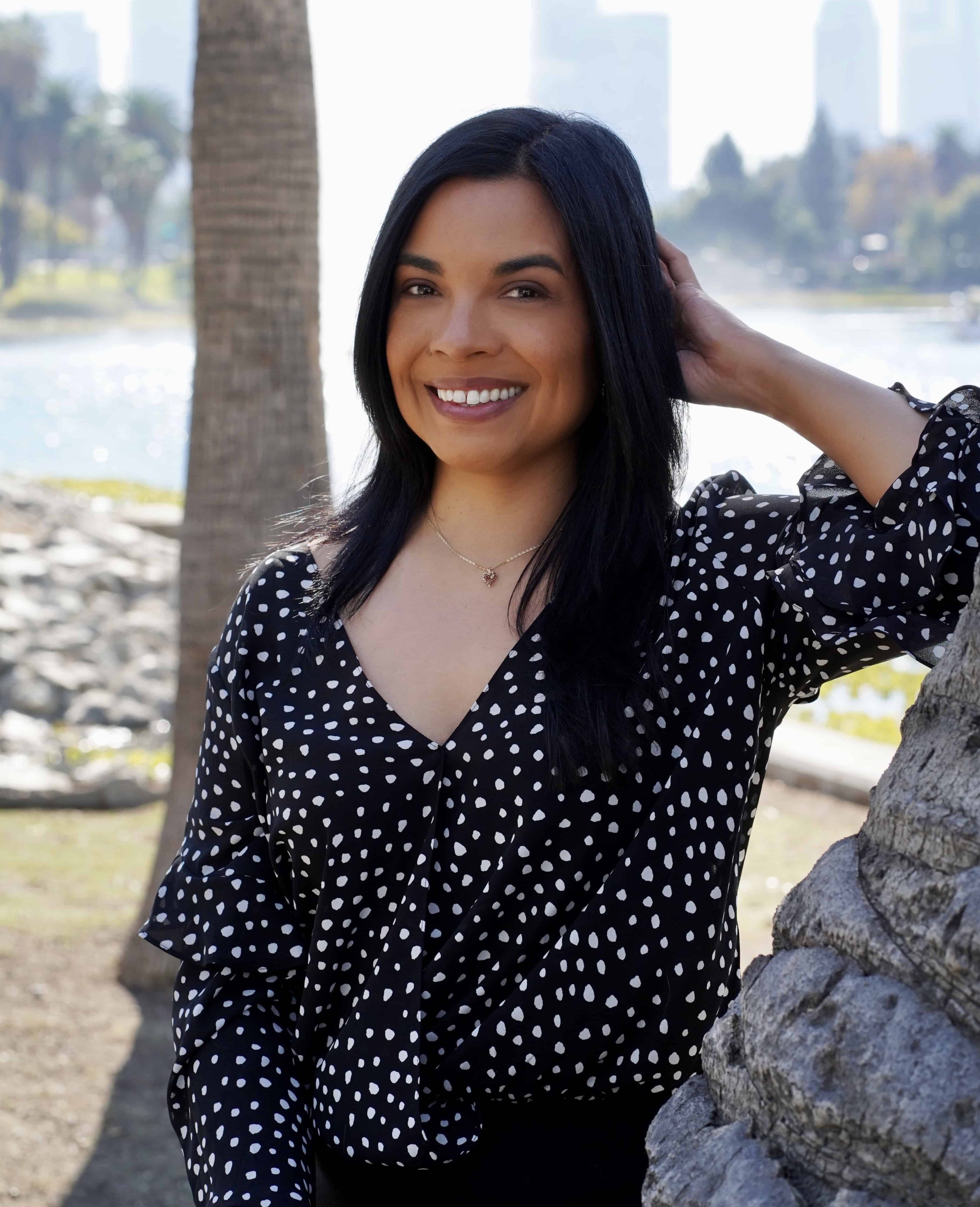 Photo of California psychologist Dr. Maya Borgueta, standing in front of a palm tree near Echo Park Lake in Los Angeles.