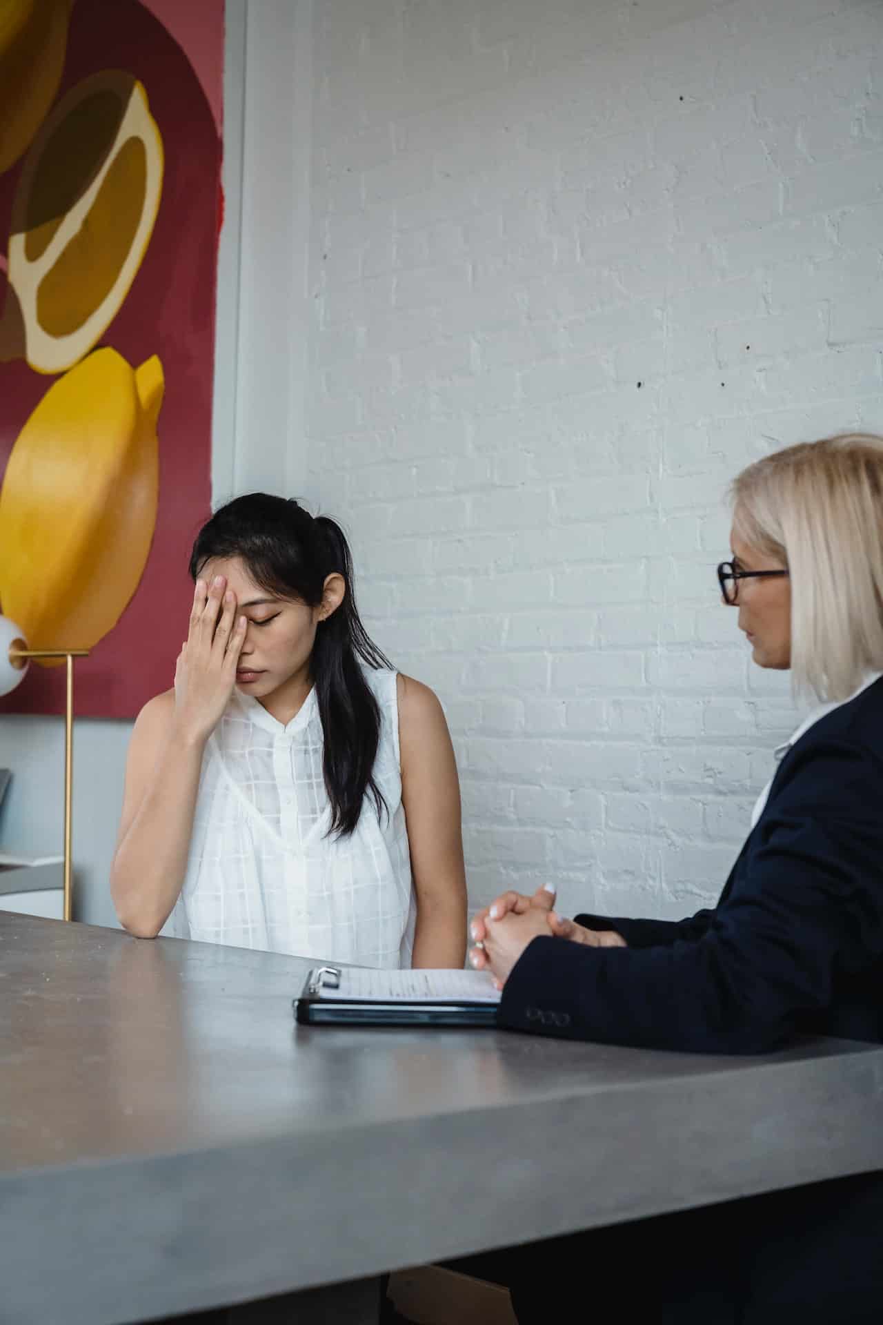 An Asian American woman looks upset in a therapy session