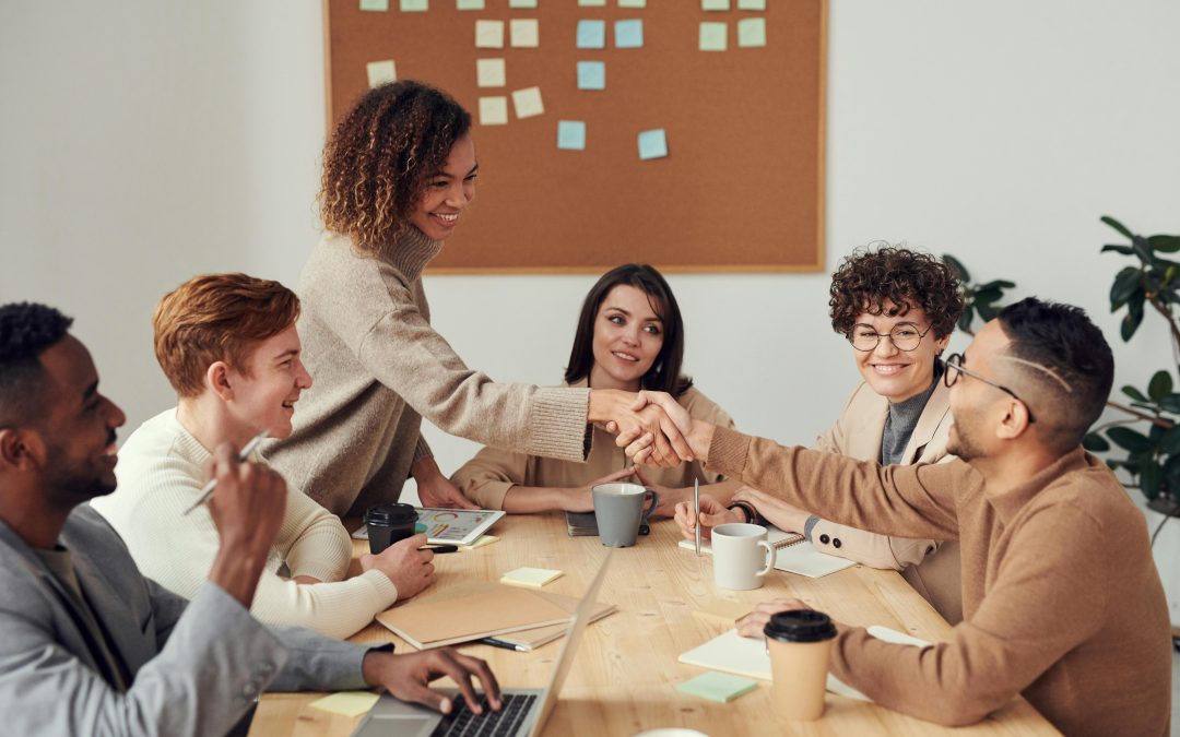 a photo of a gender and racial diverse staff in a workplace conference room