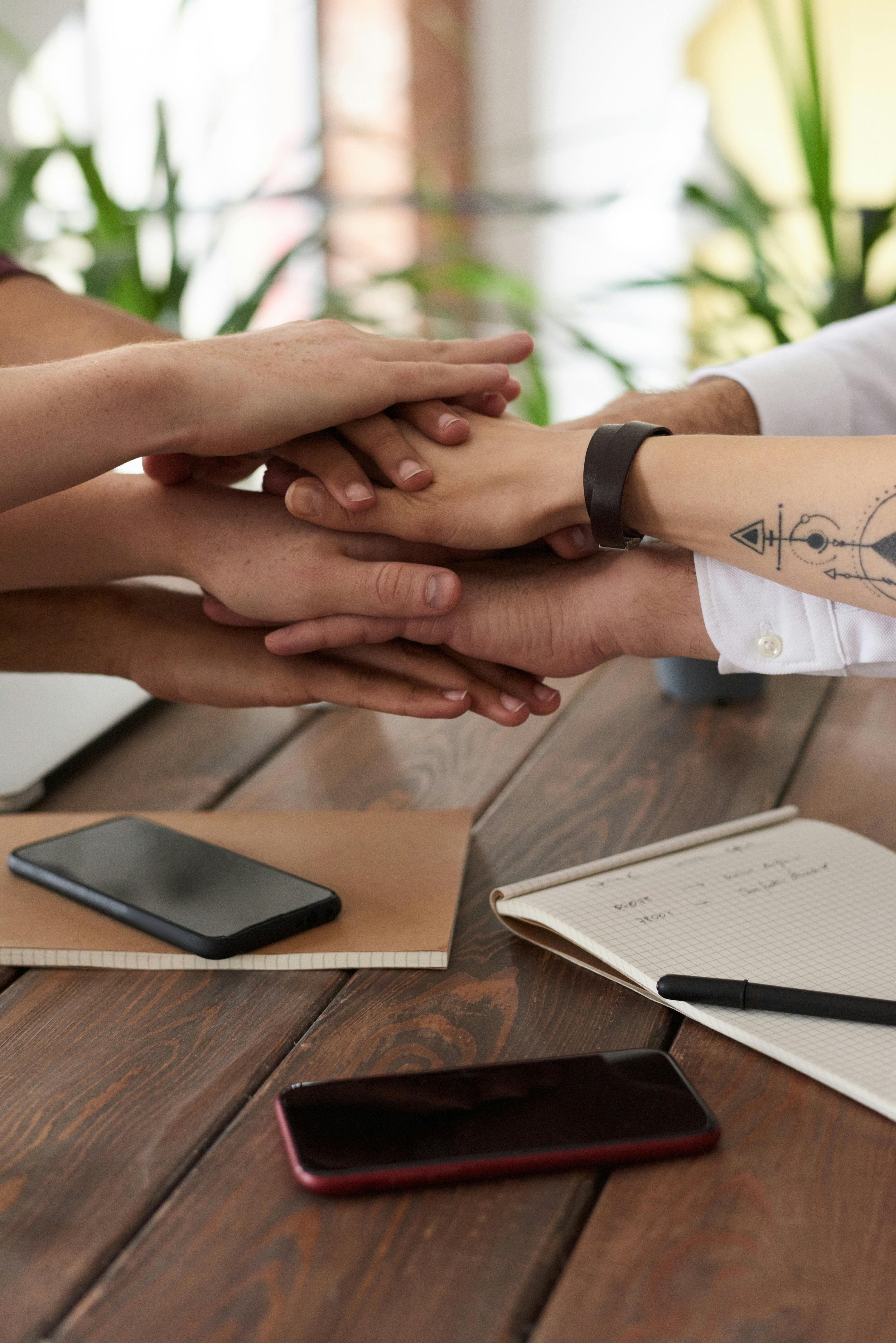 a stack of team member's hands together