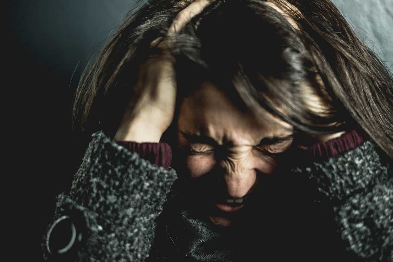cPTSD| Therapy For Trauma| Online Therapy in San Francisco | 94103 | 94107 | 94114 Woman with brunette hair whose hands are on her head, screaming in frustration.