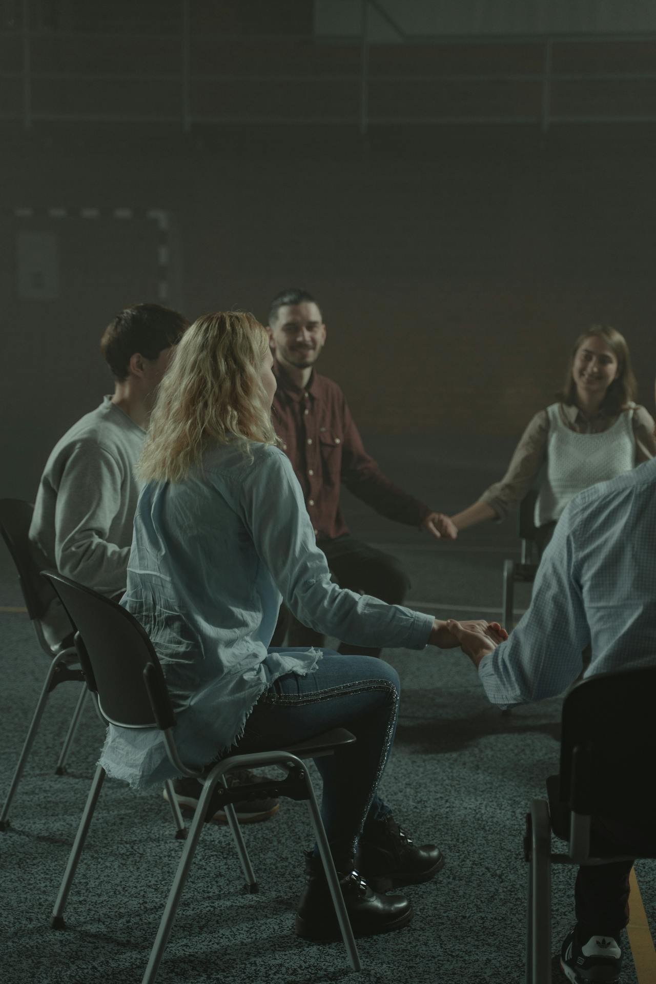 People in support group hold hands.