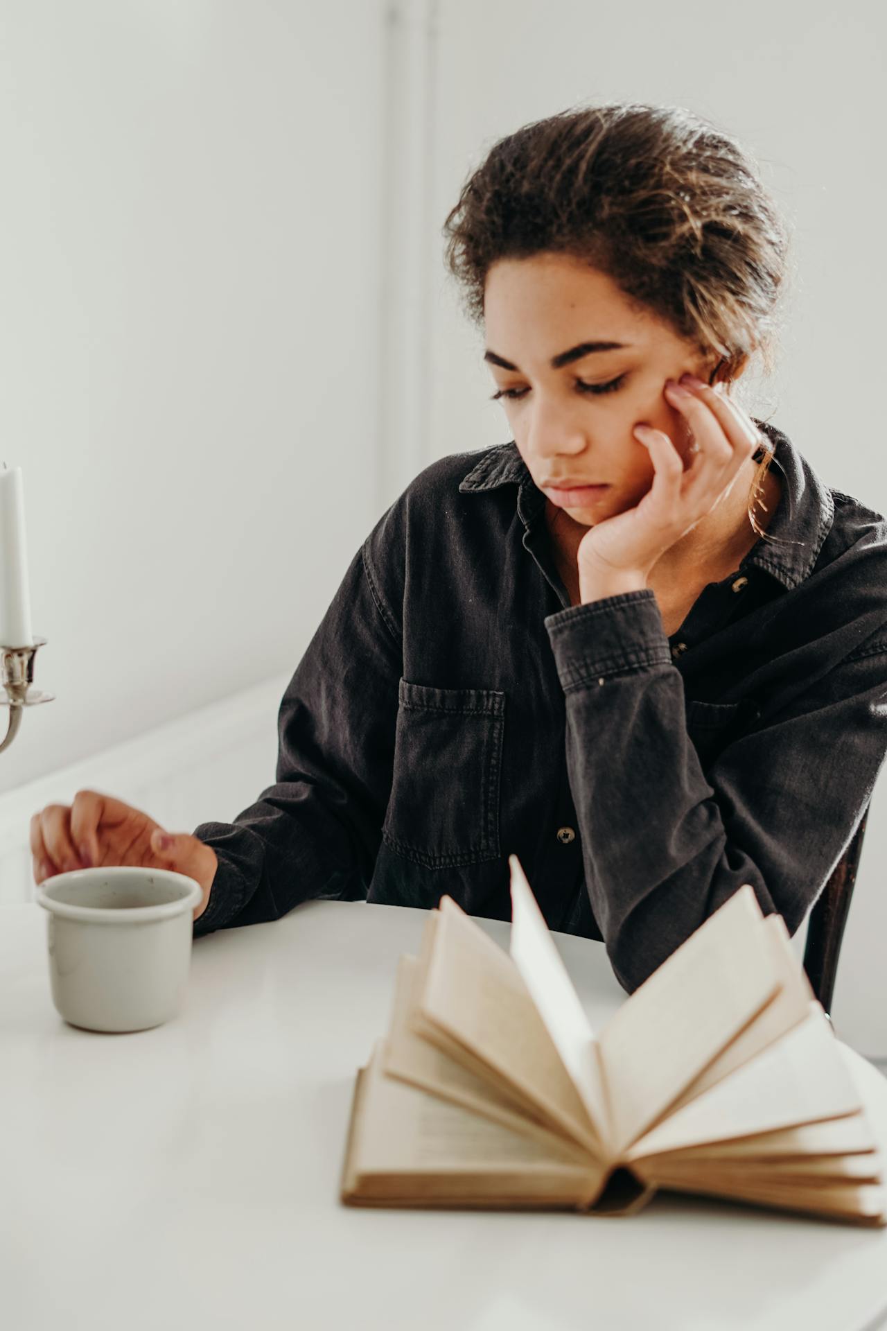 A woman with a sad expression stares at her coffee