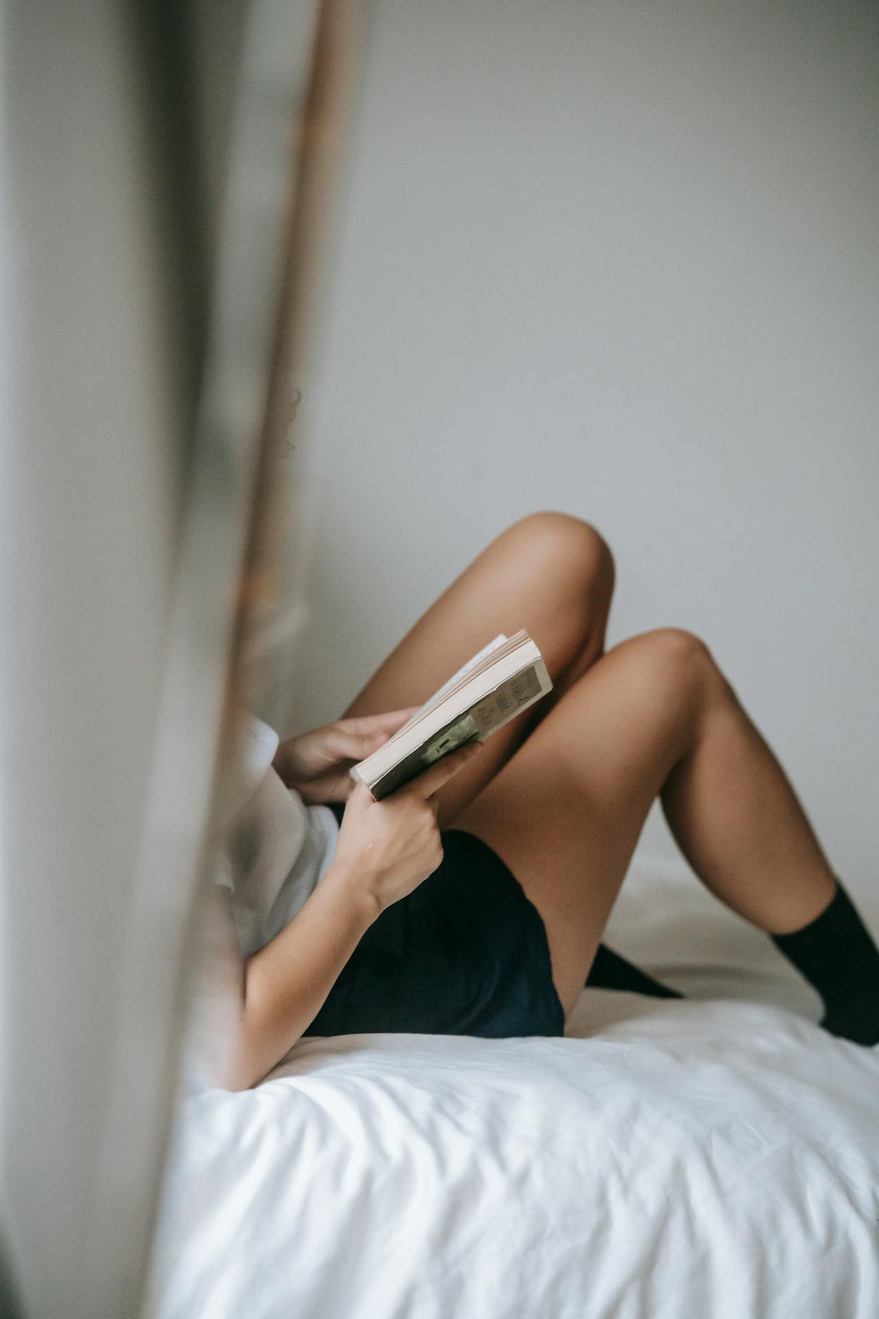 A woman sits on a bed reading